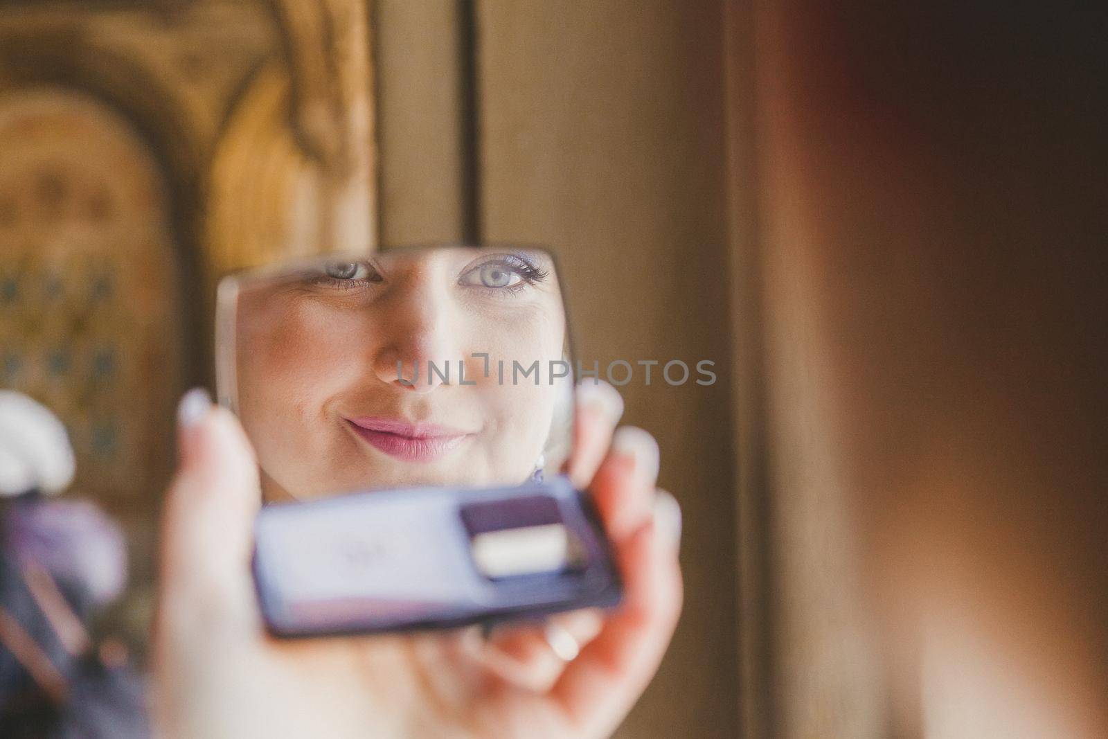 Gorgeous beautiful bride with green eyes mirror reflection face closeup by ungvar
