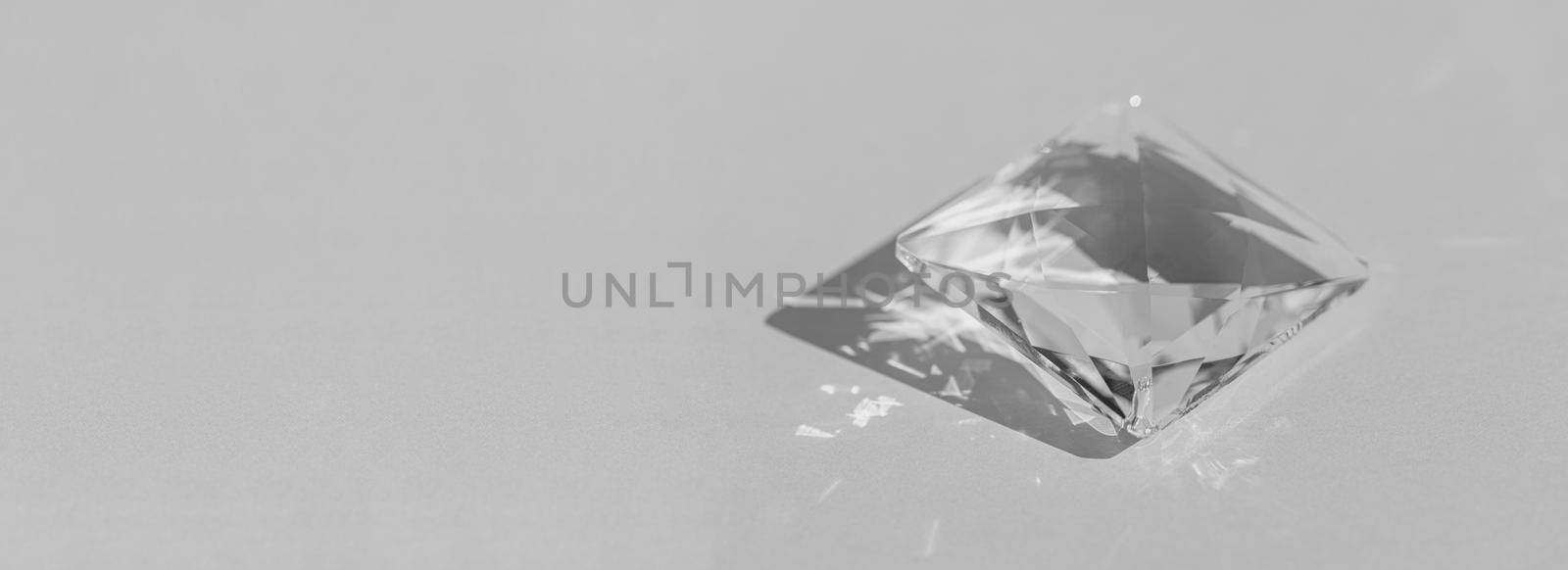 Crystal prism with light diffraction of spectrum colours and reflection with trendy light and hard shadows on a white background. Light spectrum reflected through glass prism. Banner