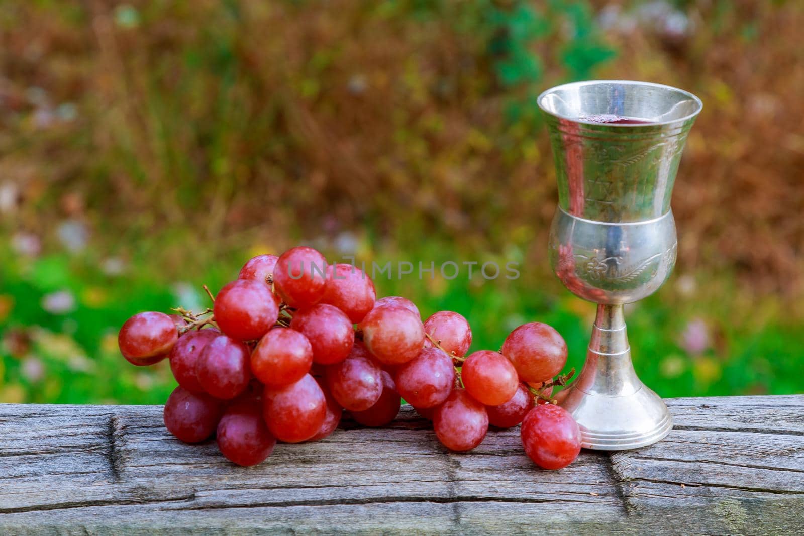 Glass of wine and grapes on yellow Jewish holidays