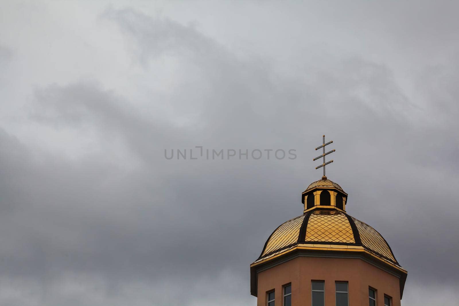 Golden domes orthodox church with cross against blue sky