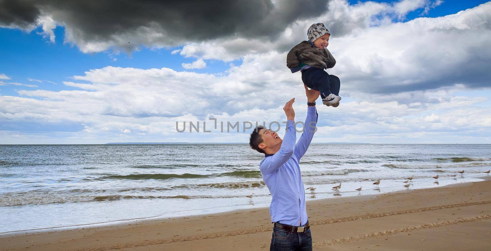 Father and son having white sand beach ocean