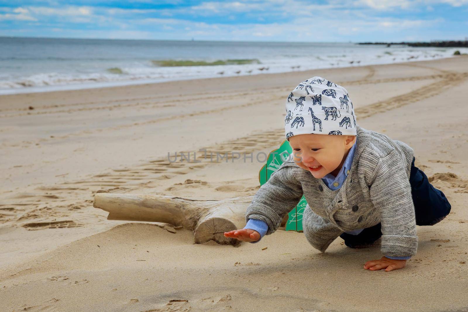 Cute baby boy playing with beach toys Boy in the ocean