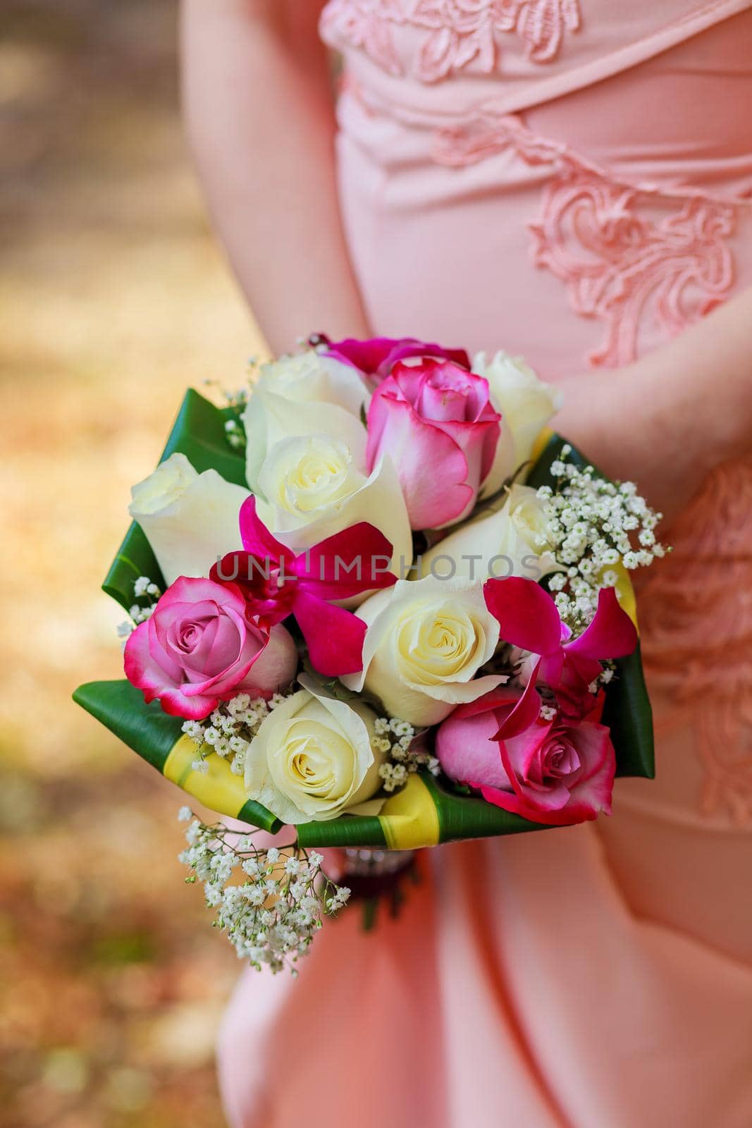 young caucasian woman in pink lace dress holds a bouquet by ungvar