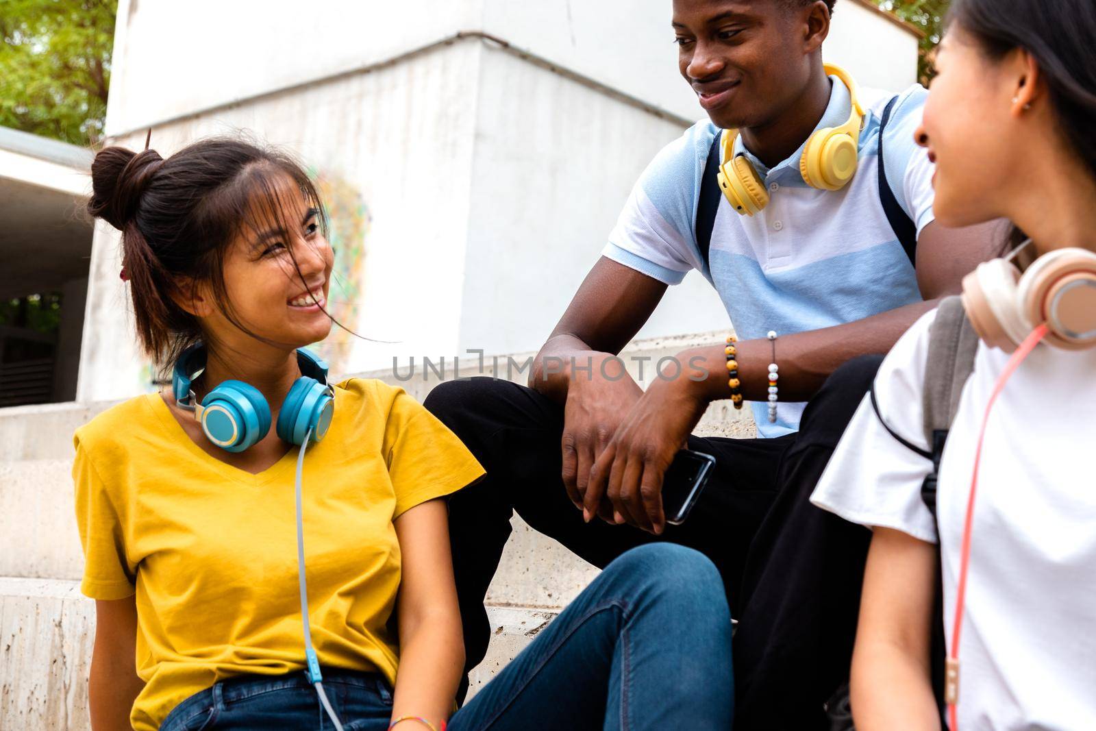 Happy teen multiracial students enjoying time outdoors talking during recess. Lifestyle and education concept.
