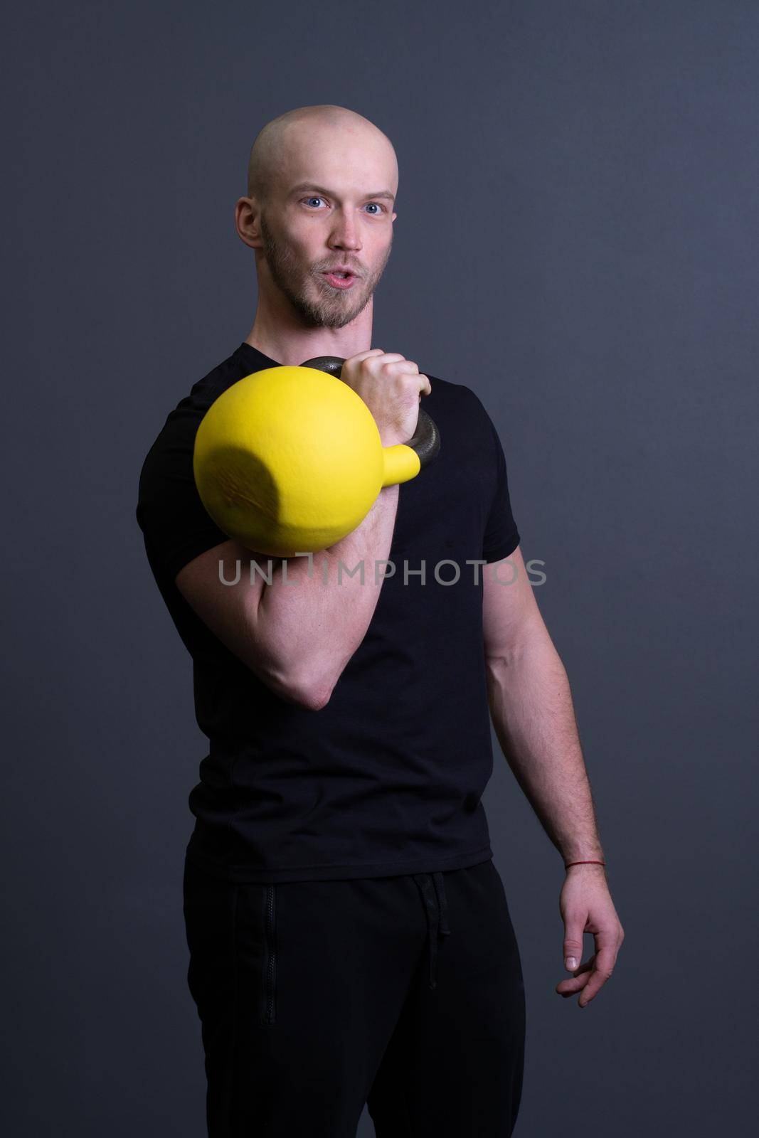 Guy with a yellow kettlebell gym anonymous young male, for sporty effort for men and up youth, malaysian fitness. Healthy interval health, cross hiit