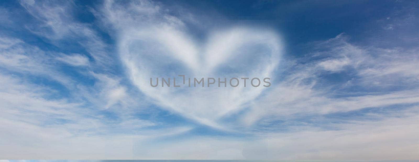 A cloud in the form of a heart. A figure from the clouds in the sky. Beautiful sky. Love. Imagination. Valentine's Day. Lovers. Fluffy cumulus cloud looks like a heart. Valentine's day symbol by Andelov13