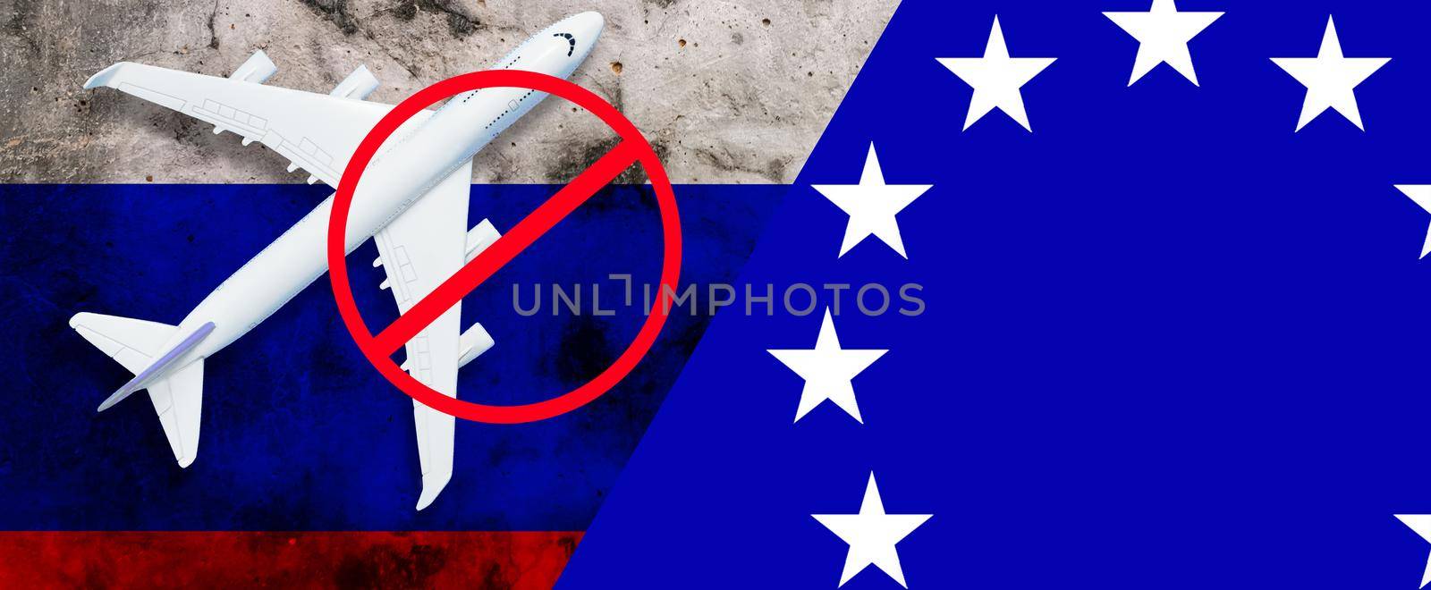 Russian flag, toy plane and barbed wire on blue background, concept of banning aircraft departing from Russia