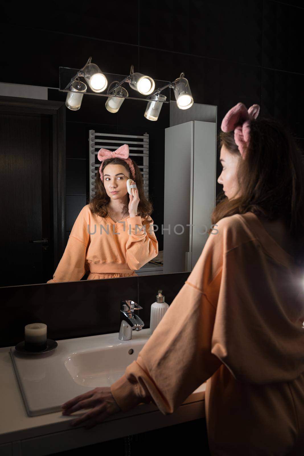 Portrait view of beautiful young woman getting ready in home bathroom. mirror face reflection. by Ashtray25