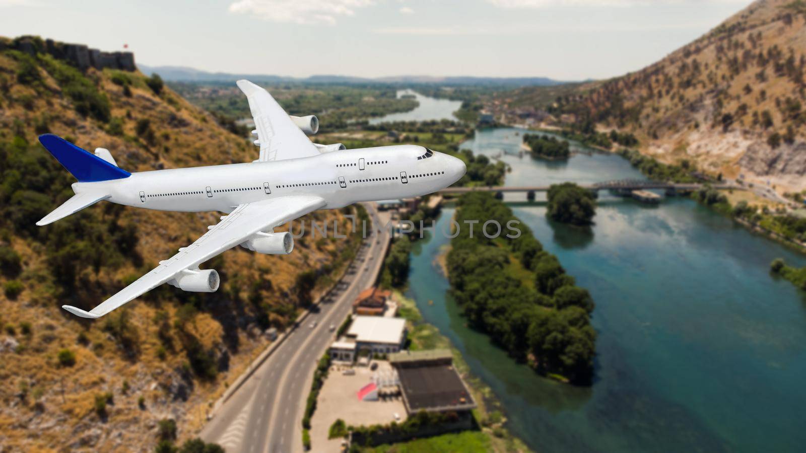 Aerial view of aircraft. Airplane is flying over mountains with forest. Business travel. Commercial plane by Andelov13