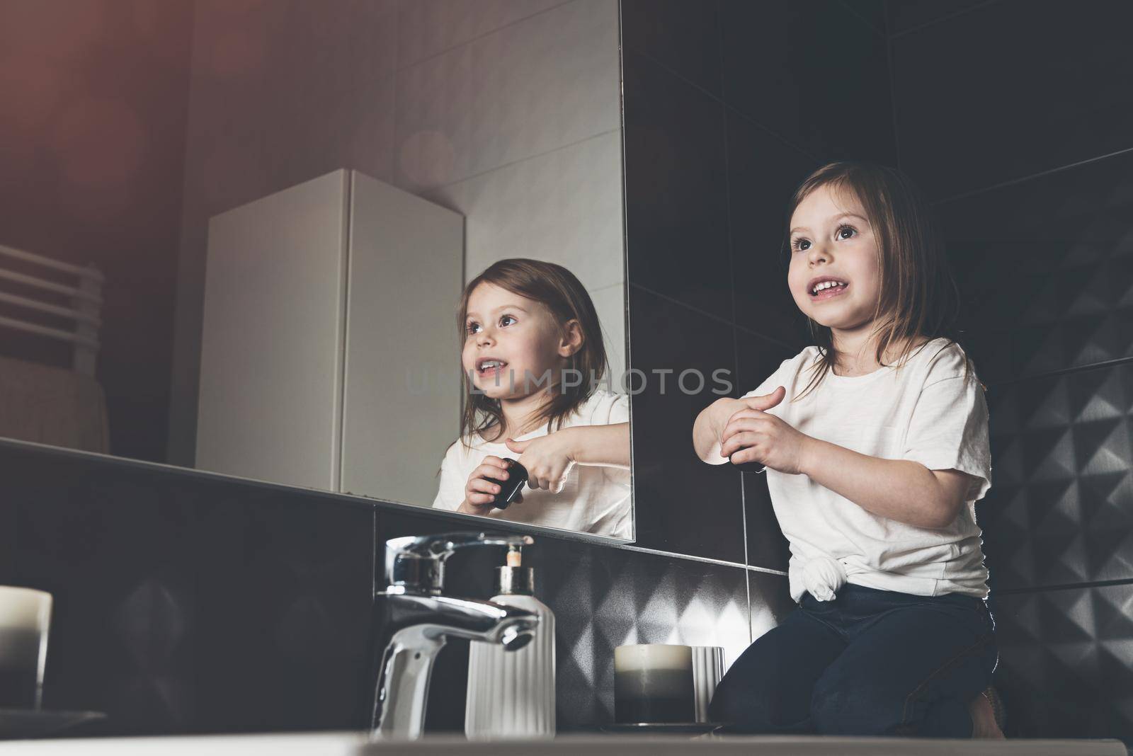 Portrait of beautiful little girl using cream for skincare. . Pretty kid cleansing or moisturize her skin. by Ashtray25