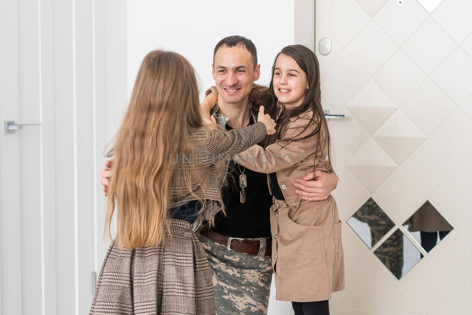Happy military father and two daughters at home