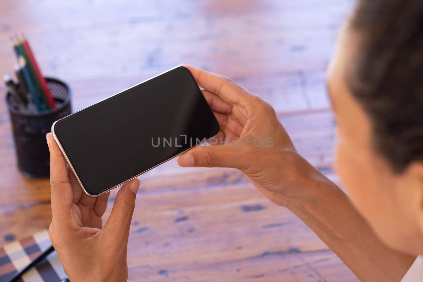 Caucasian woman using smartphone on video call at home by Wavebreakmedia