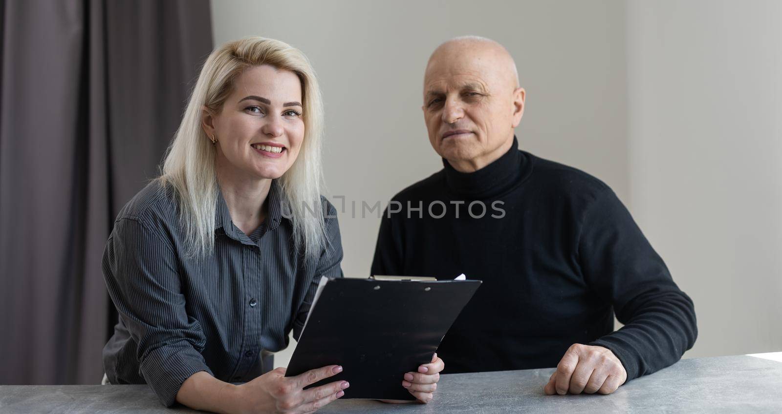 Portrait of female psychiatrist interviewing senior man during therapy session, copy space.