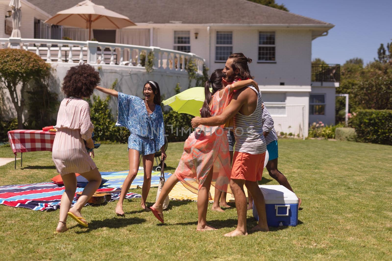 Diverse group of friends greeting each other at a pool party. Hanging out and relaxing outdoors in summer.