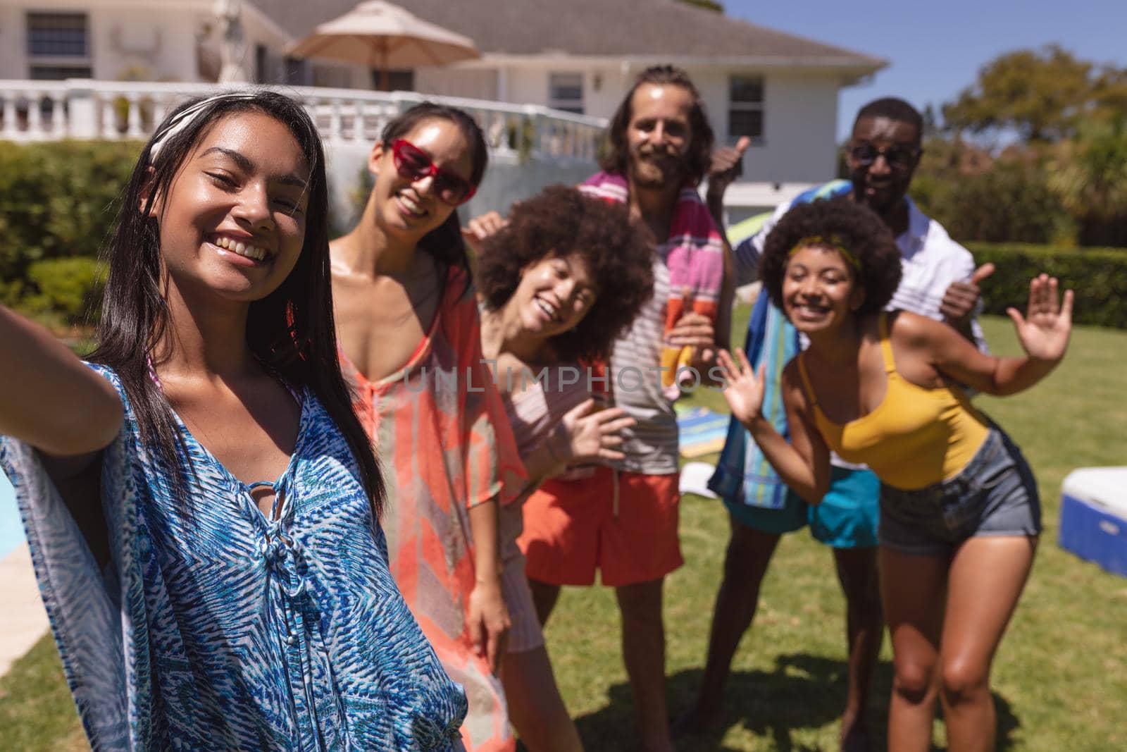 Portrait of diverse group of friends taking selfie at a pool party. Hanging out and relaxing outdoors in summer.