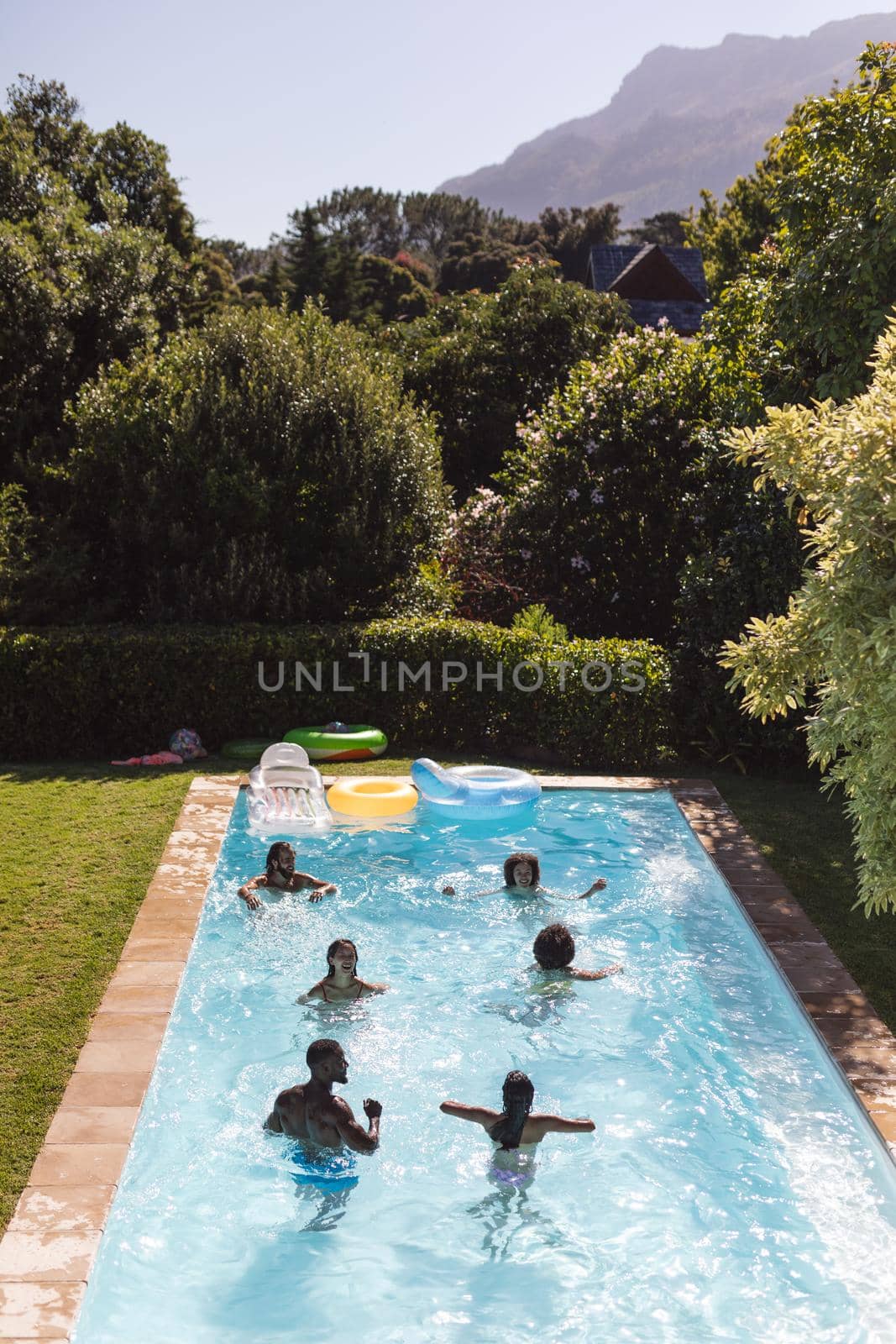 Diverse group of friends having fun in swimming pool by Wavebreakmedia