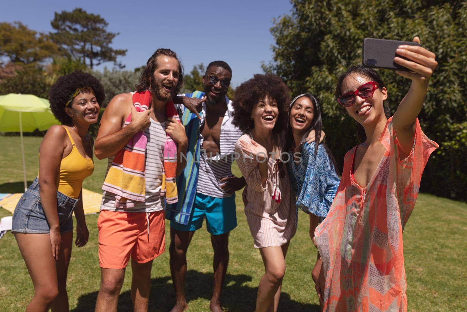 Diverse group of friends taking selfie at a pool party by Wavebreakmedia