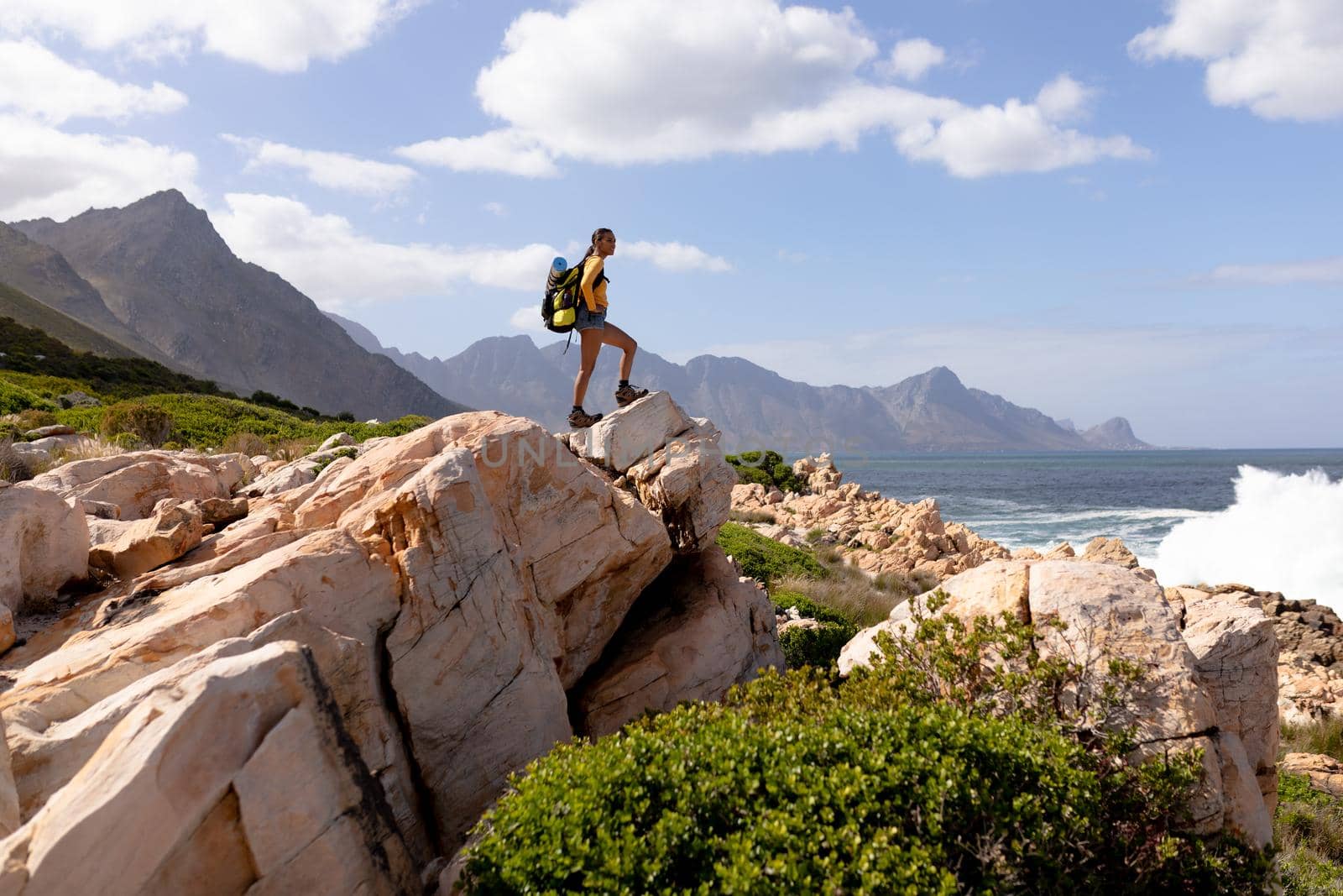 Fit afrcan american woman wearing backpack hiking on the coast by Wavebreakmedia