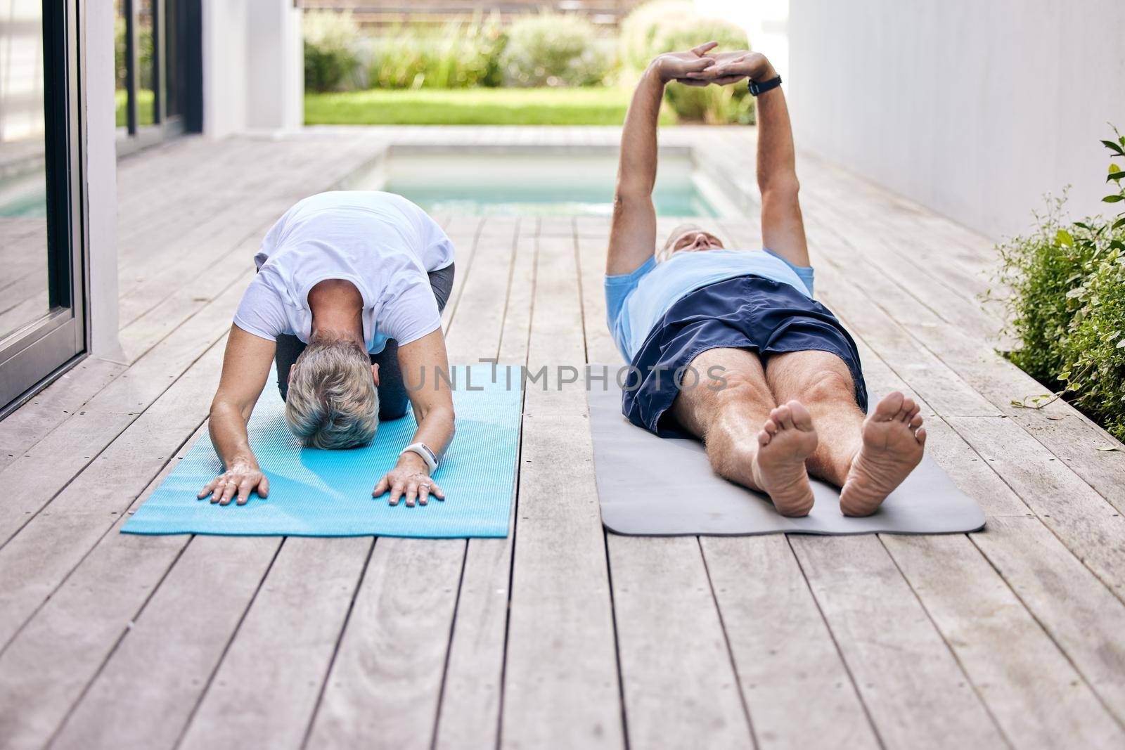 Starting off with some light stretches. Shot of a mature couple exercising together outdoors. by YuriArcurs