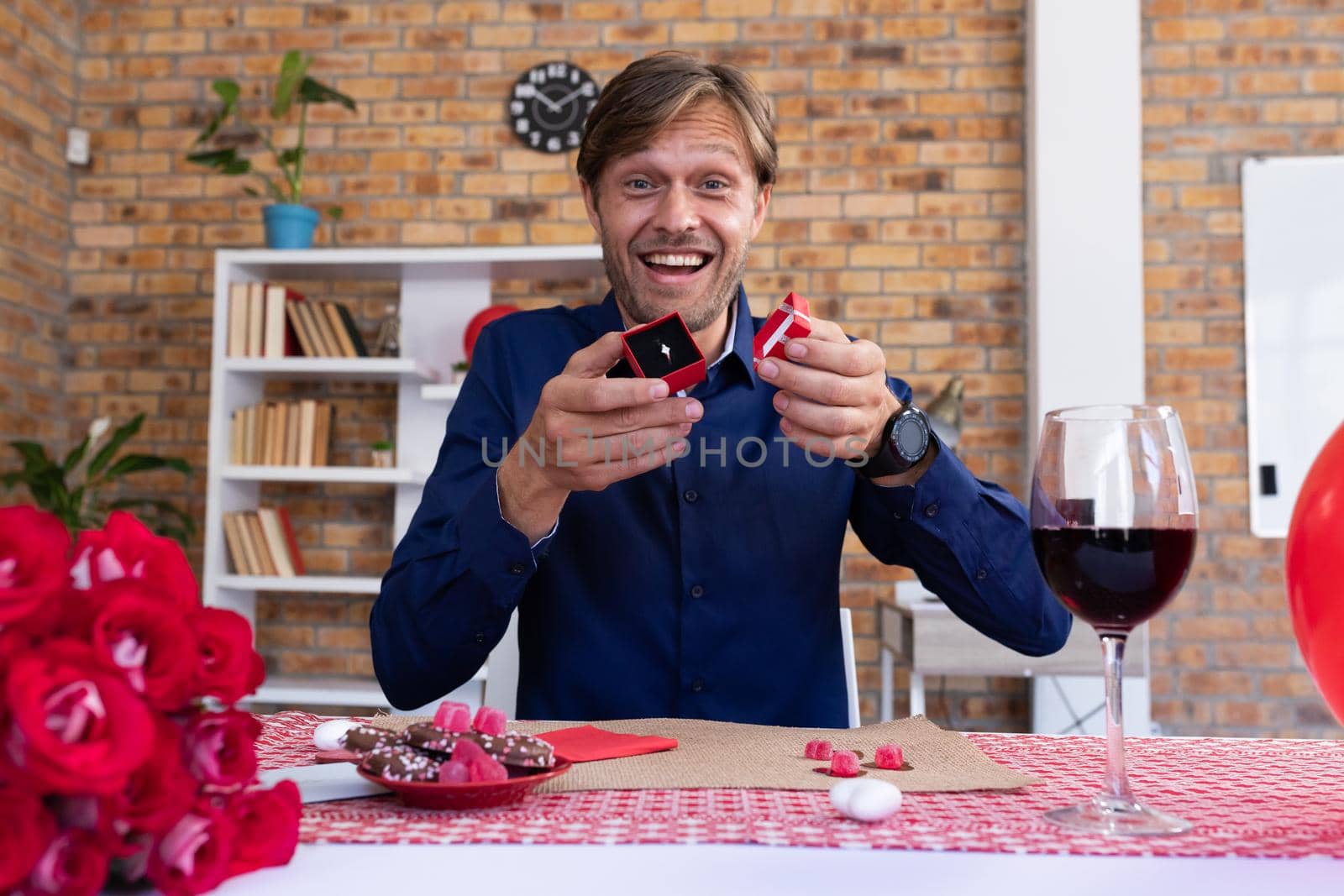 Caucasian man making video call opening a small gift box with ring and smiling by Wavebreakmedia