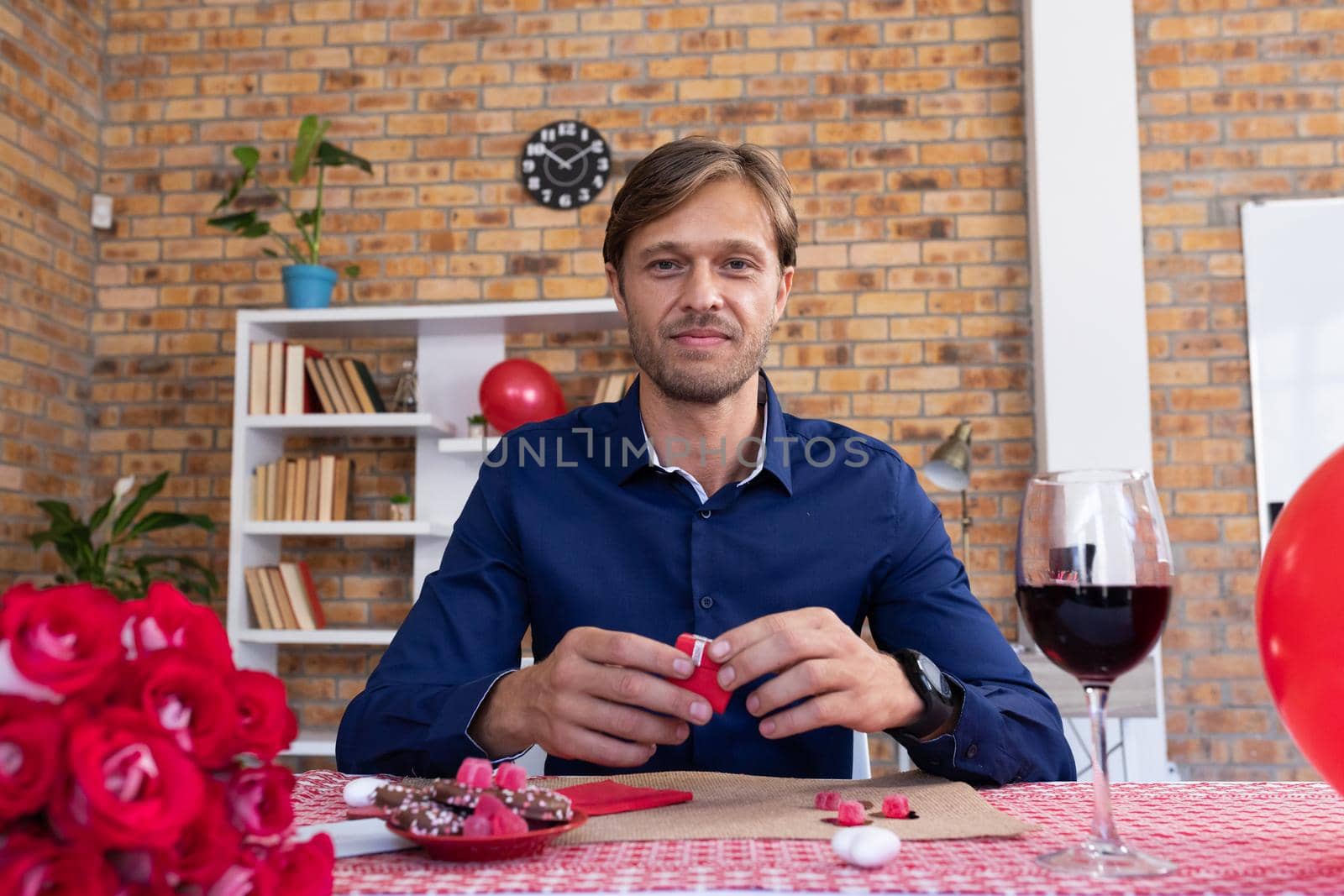 Caucasian man making video call opening a small gift box and smiling by Wavebreakmedia