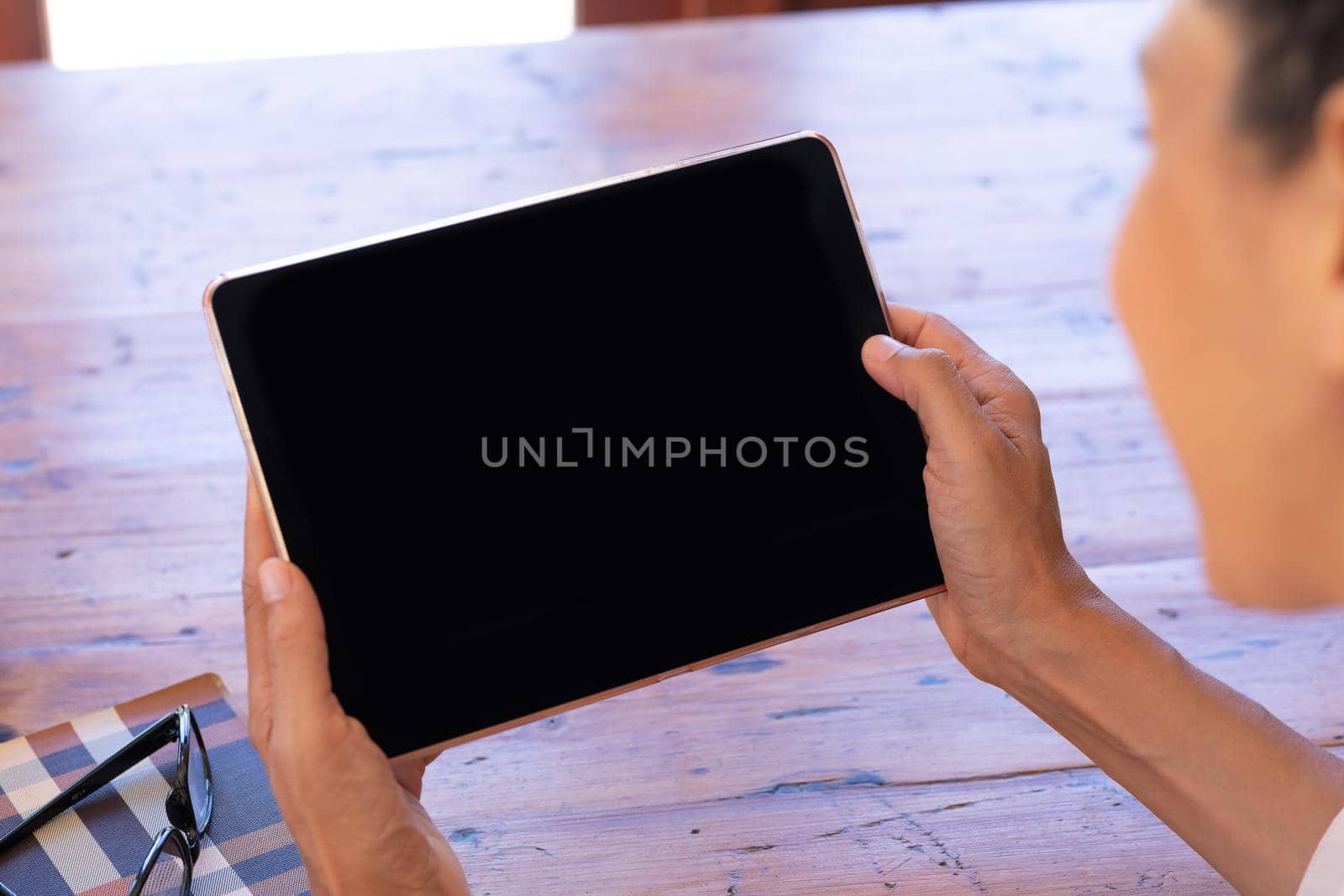 Caucasian woman using digital table sitting by table at home. Staying at home in self isolation during quarantine lockdown.