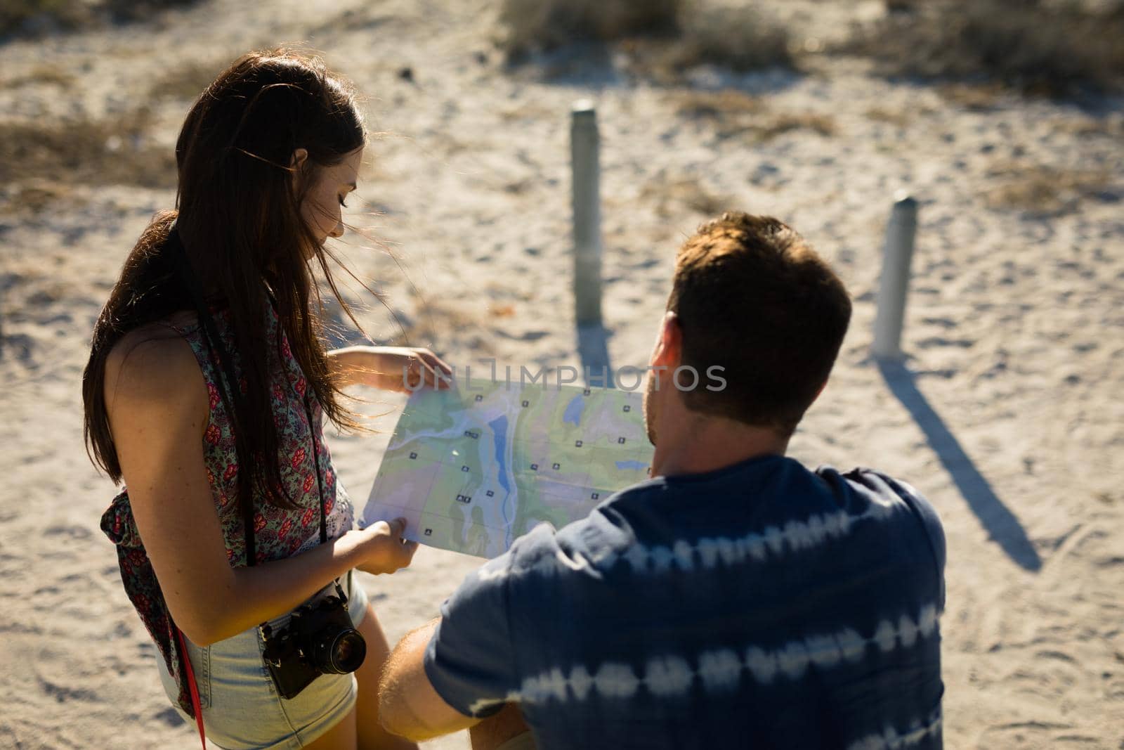 Happy caucasian couple on beach by the sea reading roadmap. beach break on summer holiday trip