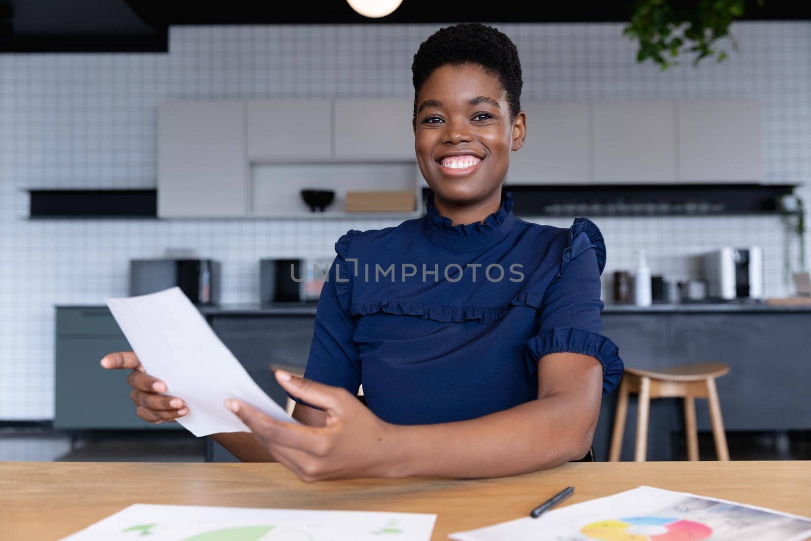 Mixed race businesswoman sitting having video chat going through paperwork in modern office. business modern office workplace technology.