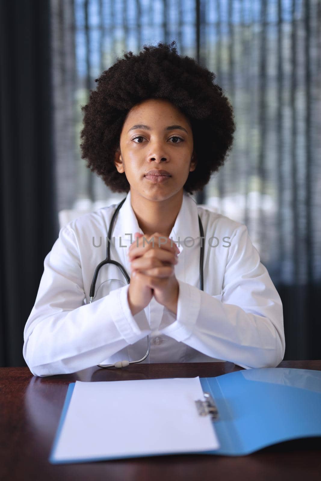 African american female doctor sitting making video call consultation by Wavebreakmedia