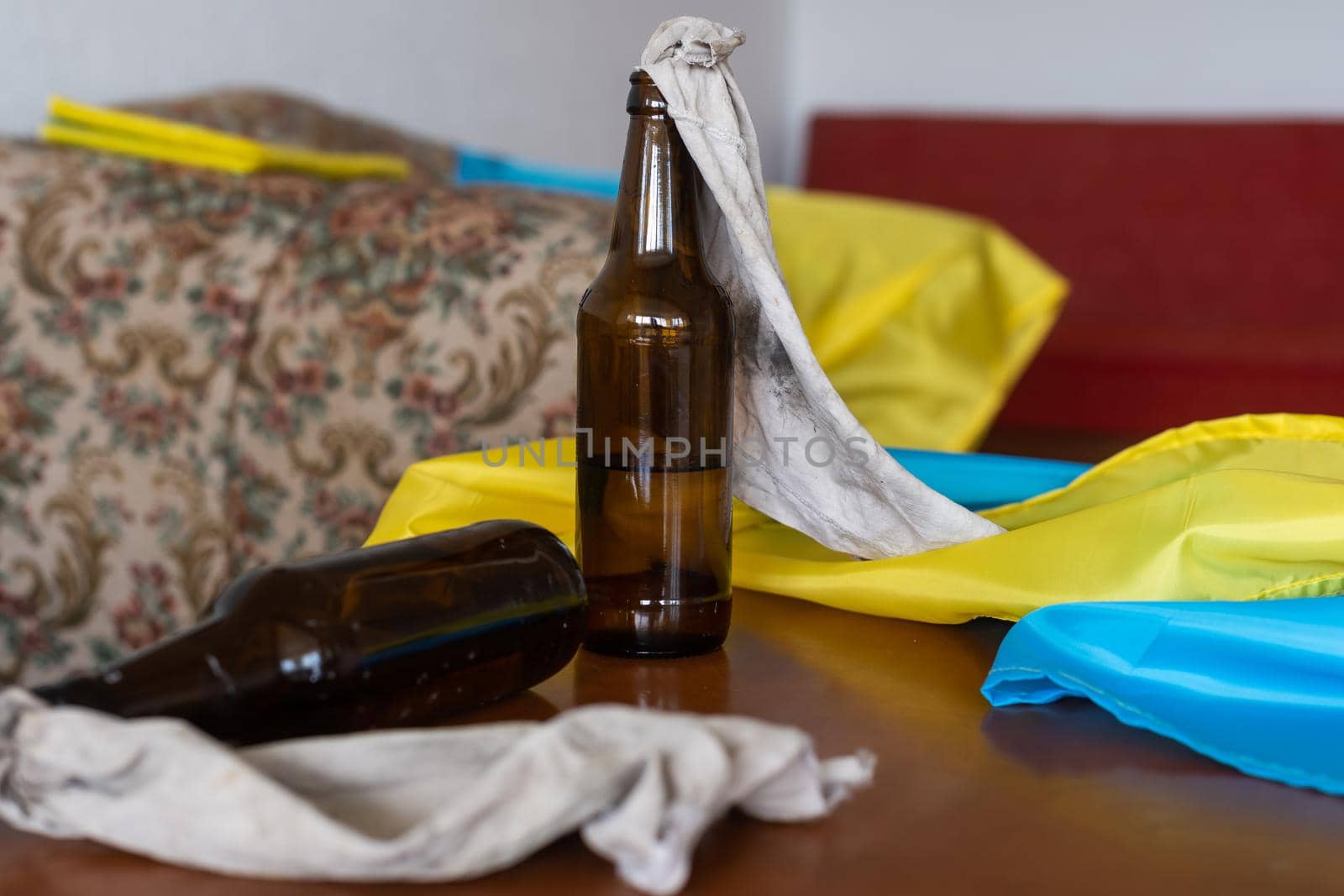 Molotov cocktail bottle on flag of ukraine background.