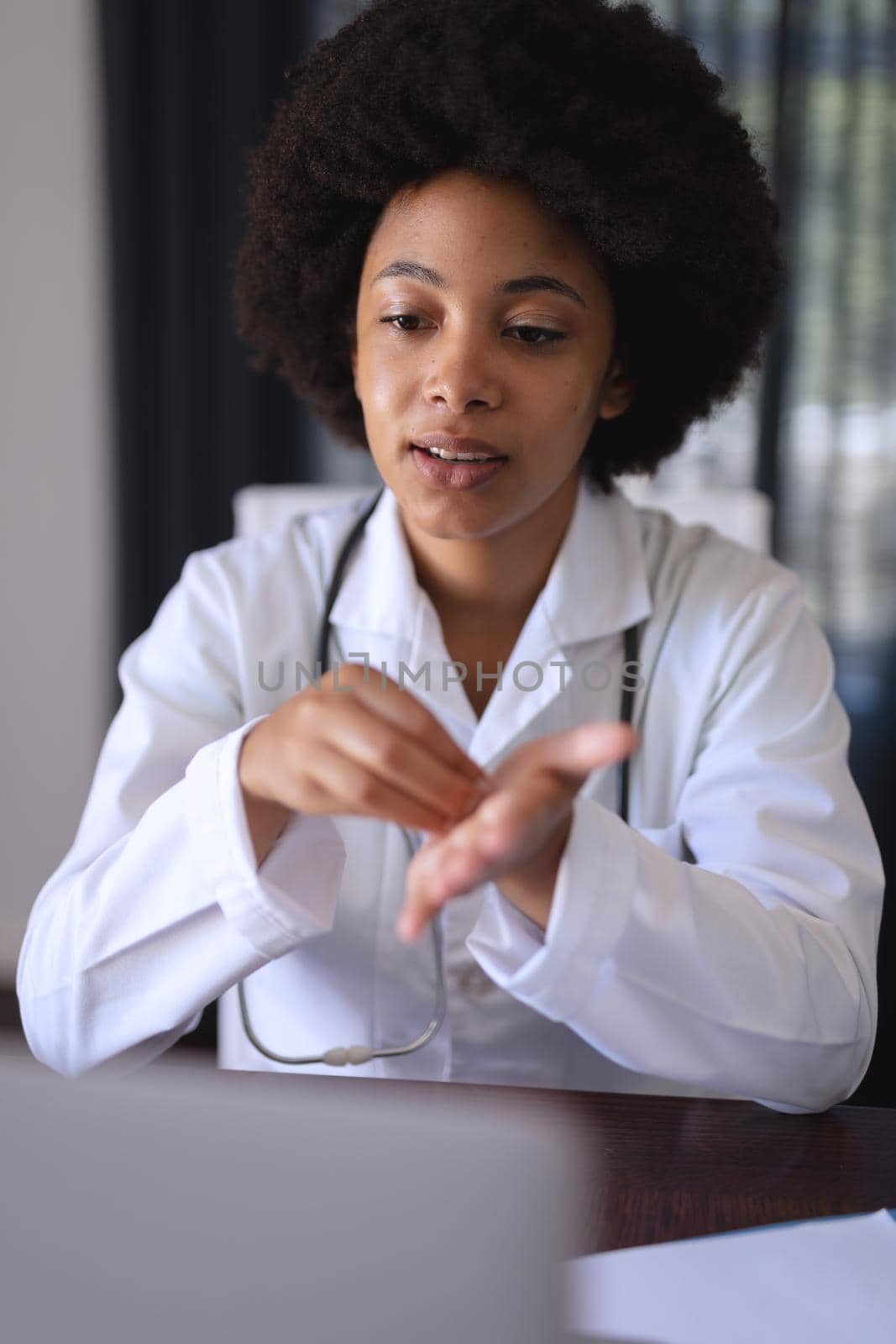 African american female doctor sitting making video call consultation by Wavebreakmedia