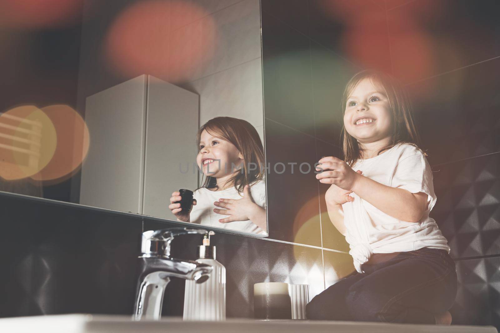 Portrait of beautiful little girl using cream for skincare. . Pretty kid cleansing or moisturize her skin. Teenage and child problems, hygiene, clean and fresh young skin.