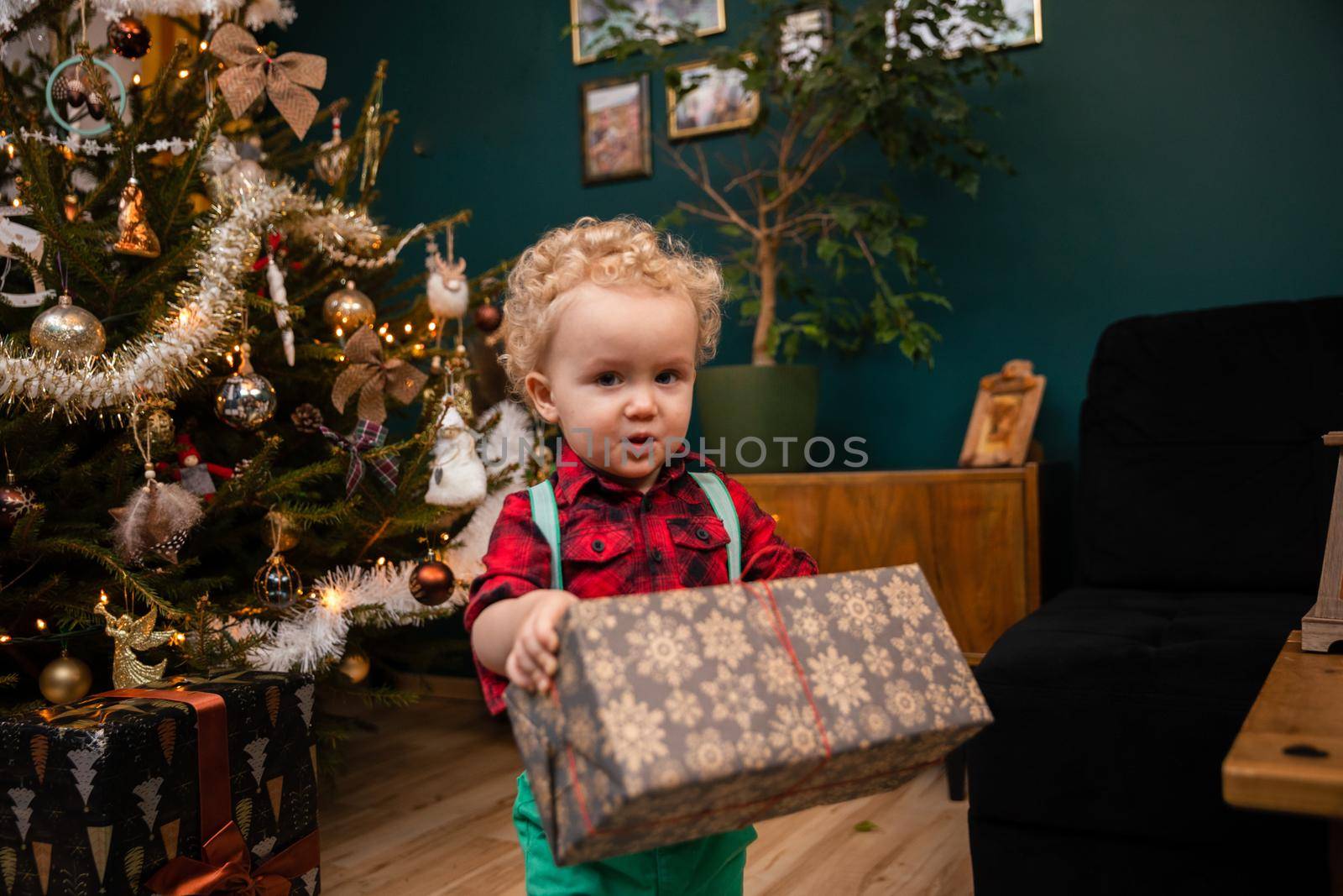 A child holds a gift in his hands. An old Polish tradition of giving gifts during a Christmas feast.