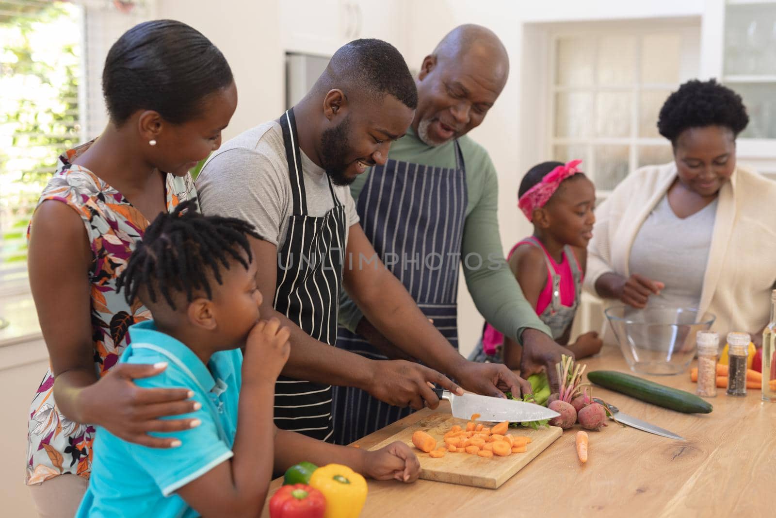 Happy african american parents cooking with son and daughter and grandparents in the kitchen by Wavebreakmedia