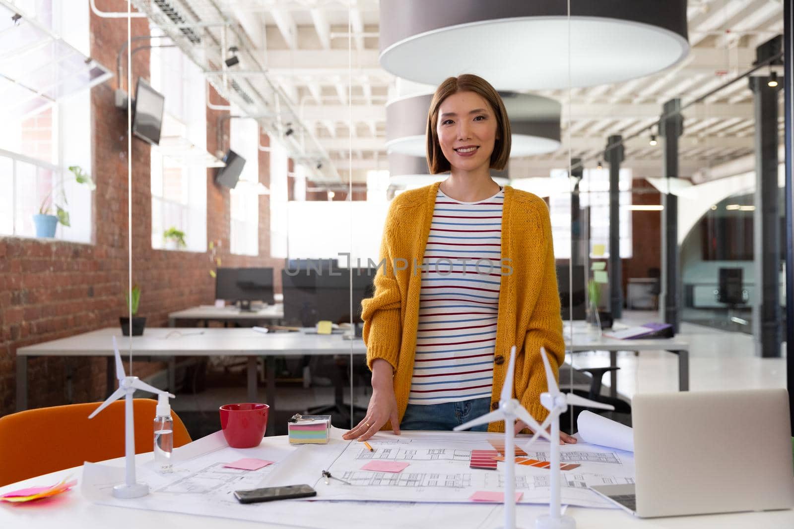 Portrait of asian businesswoman writing and placing memo notes on blueprint. independent creative design business.