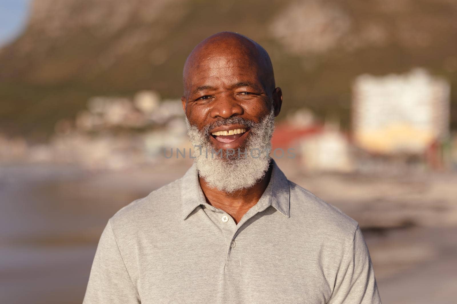 Portrait of senior african american man smiling while standing on the beach. travel vacation retirement lifestyle concept
