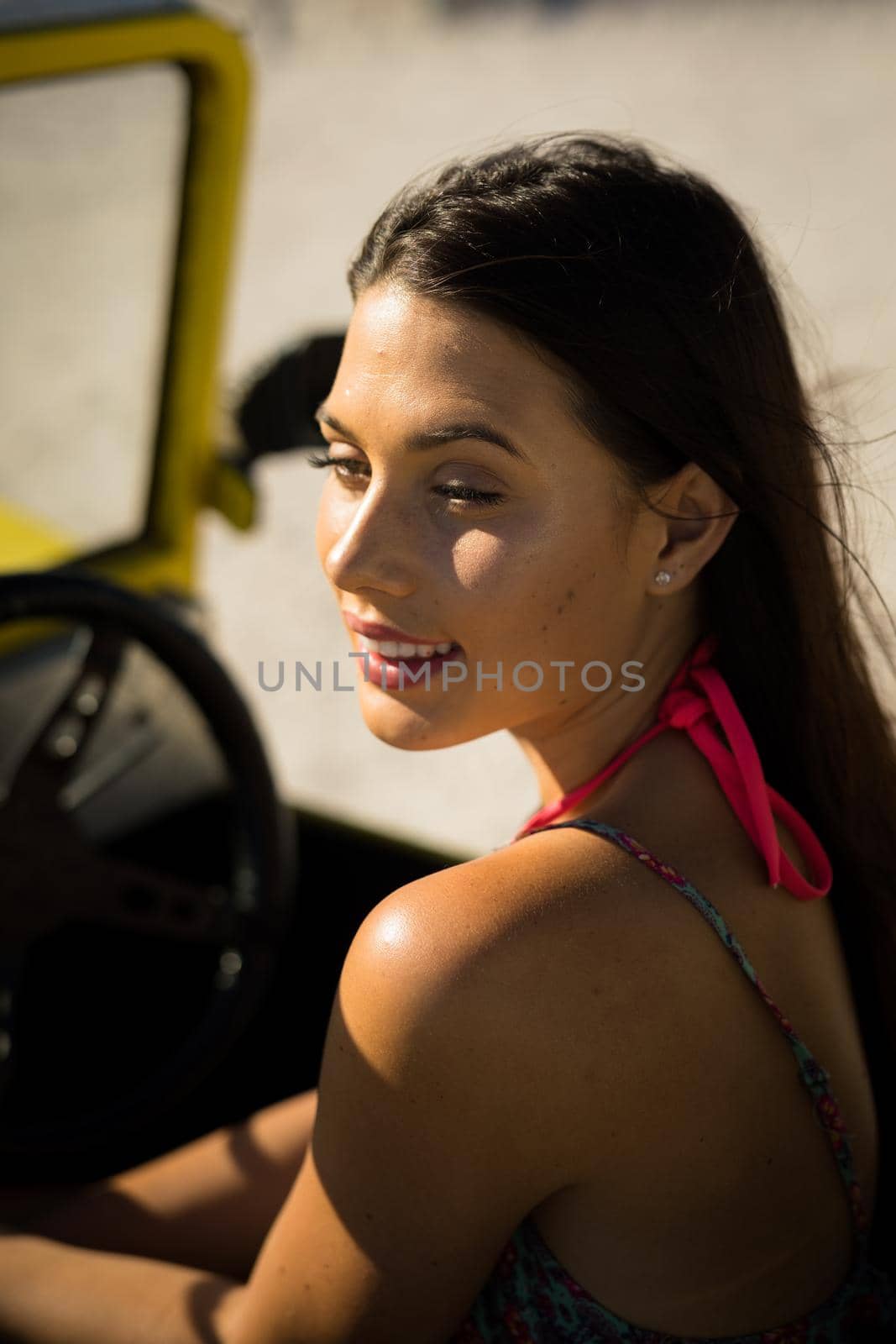 Happy caucasian woman sitting in beach buggy by the sea. beach break on summer holiday road trip.