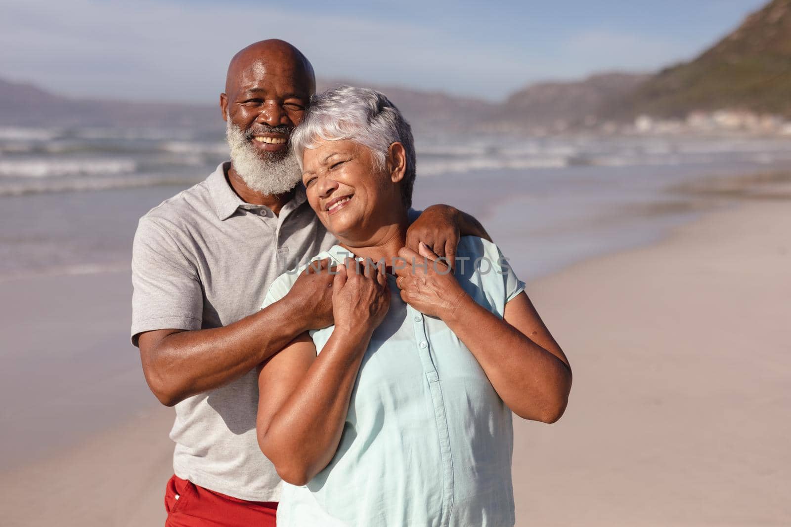 Happy senior african american couple embracing each other on the beach by Wavebreakmedia