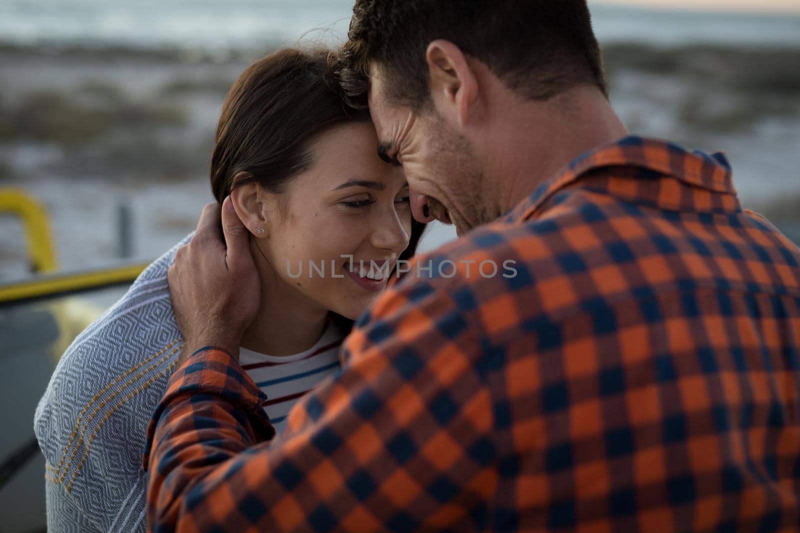 Happy caucasian couple on beach at the sea touching foreheads by Wavebreakmedia