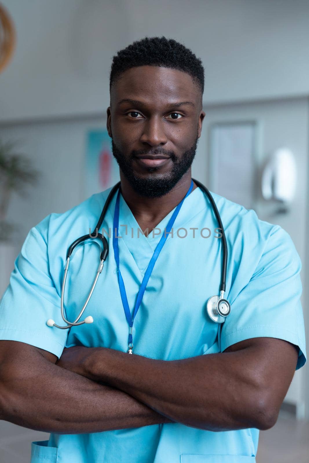 Portrait of african american male doctor with stethoscope wearing scrubs in hospital. medicine, health and healthcare services during covid 19 coronavirus pandemic.