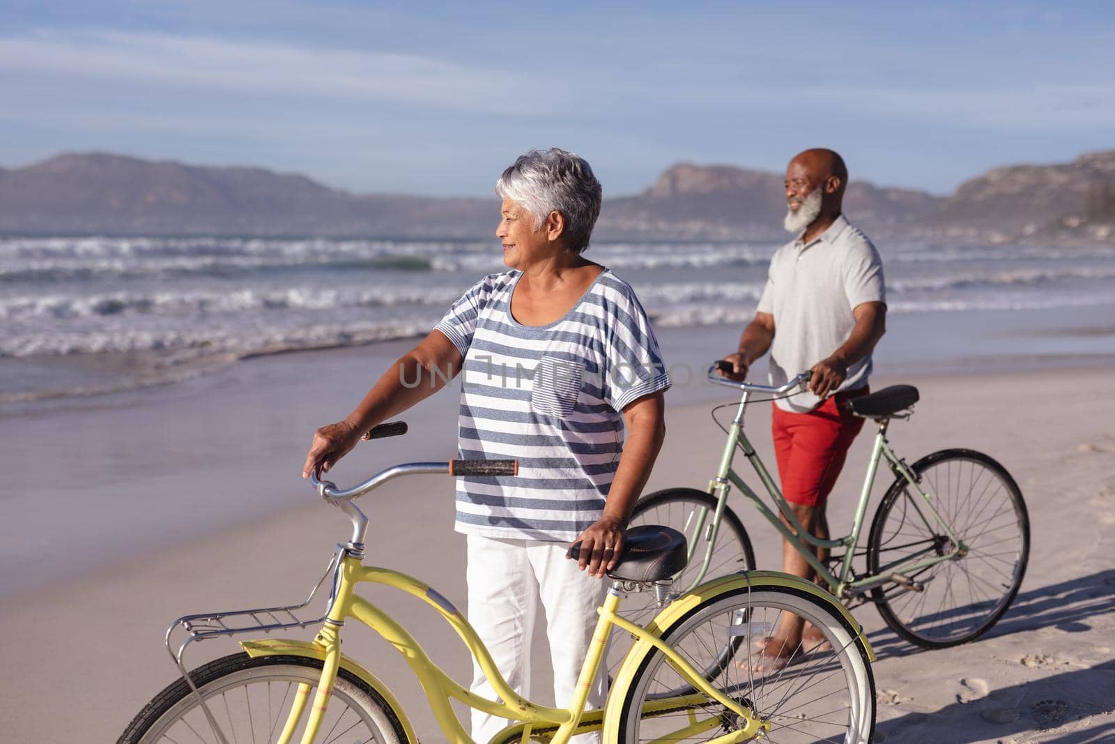 Senior african american couple with bicycles standing on the beach by Wavebreakmedia