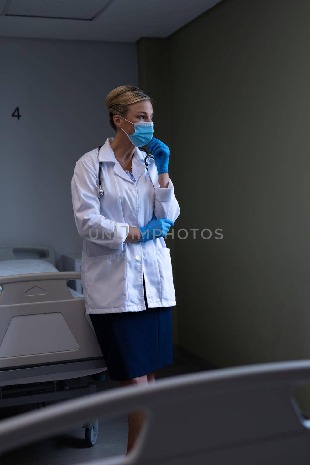 Portrait of caucasian female doctor wearing mask and latex gloves looking ahead. medicine, health and healthcare services during coronavirus covid 19 pandemic.