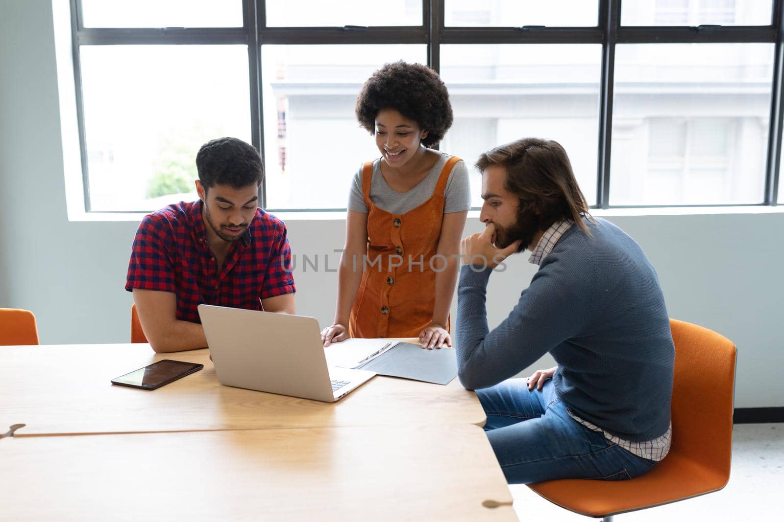 Diverse group of business people working in creative office. group of people discussing work and using laptop. business people and work colleagues at a busy creative office.