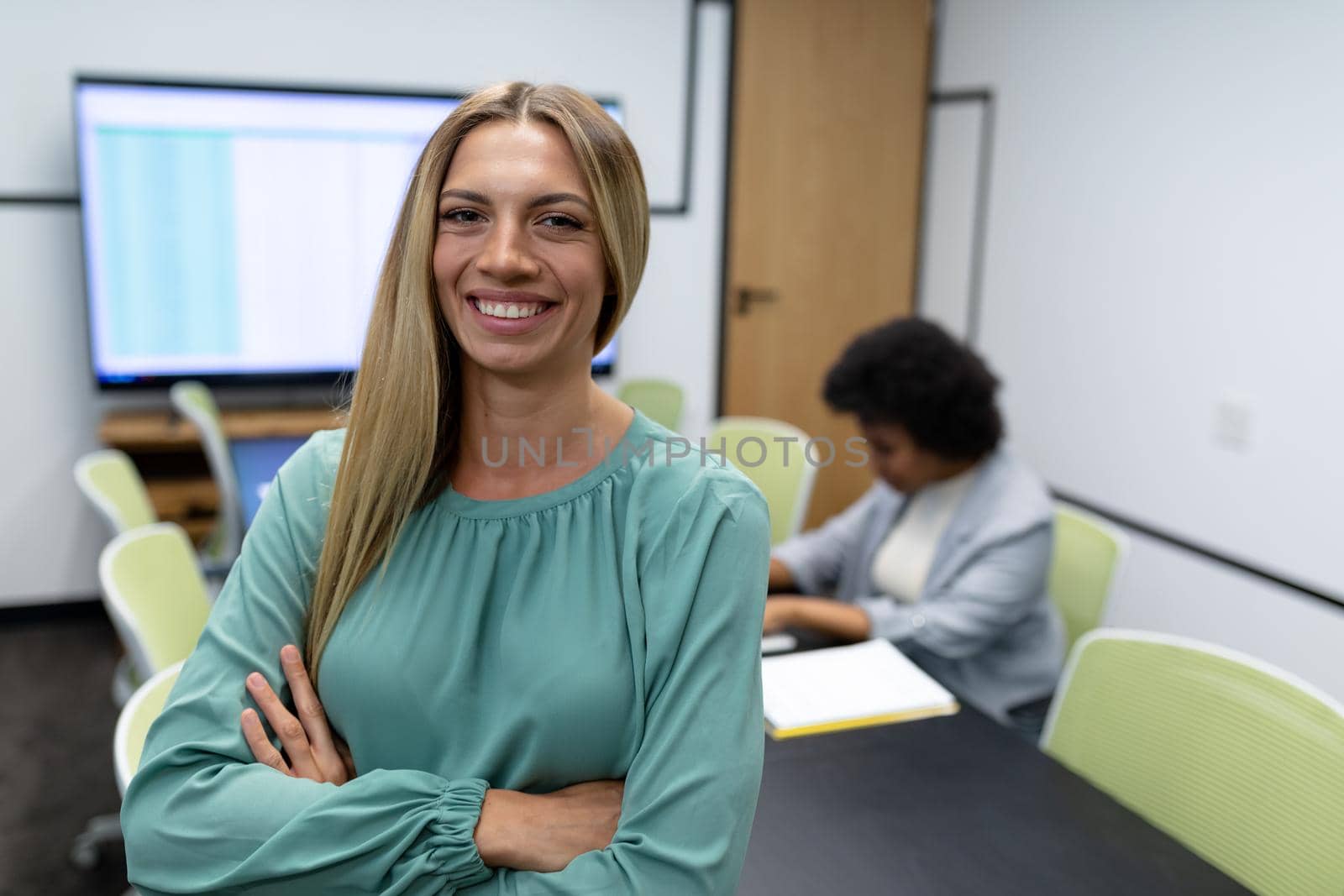 Portrait of caucasian businesswoman in meeting room looking to camera and smiling. business person at work in modern office.