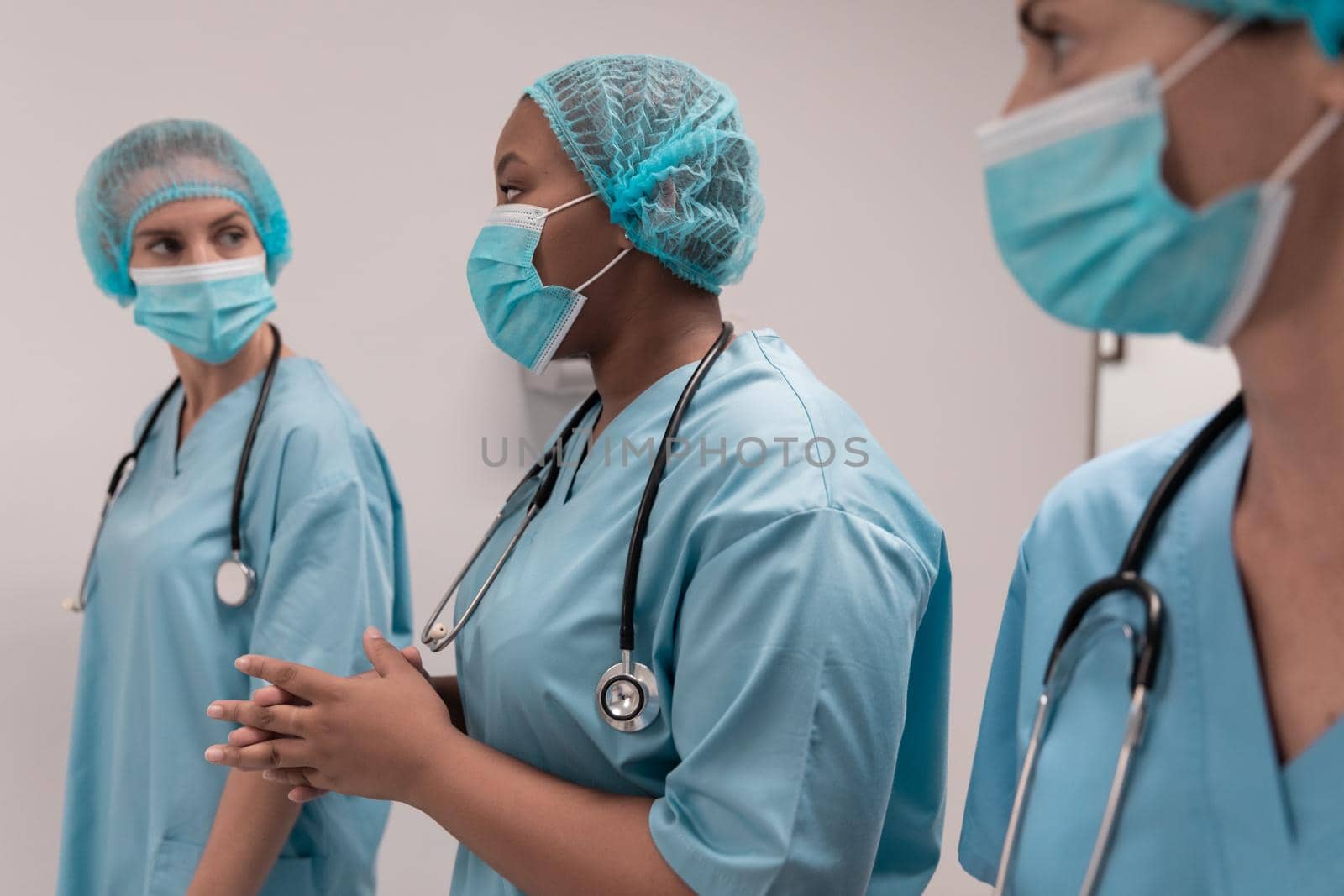 Portrait of diverse group of male and female doctors standing in operating theatre. medicine, health and healthcare services.