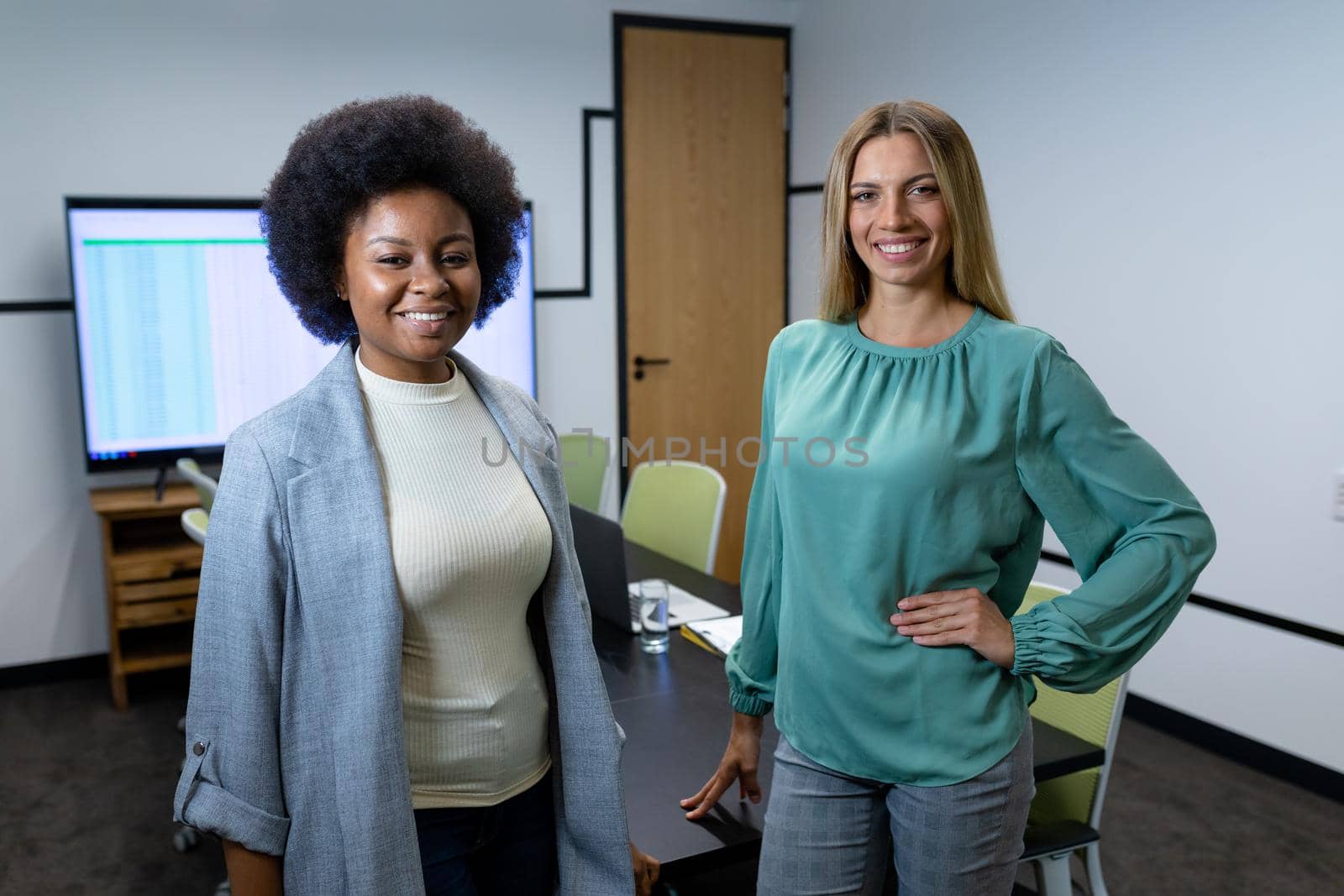 Portrait of diverse female business colleagues in meeting room looking to camera and smiling by Wavebreakmedia