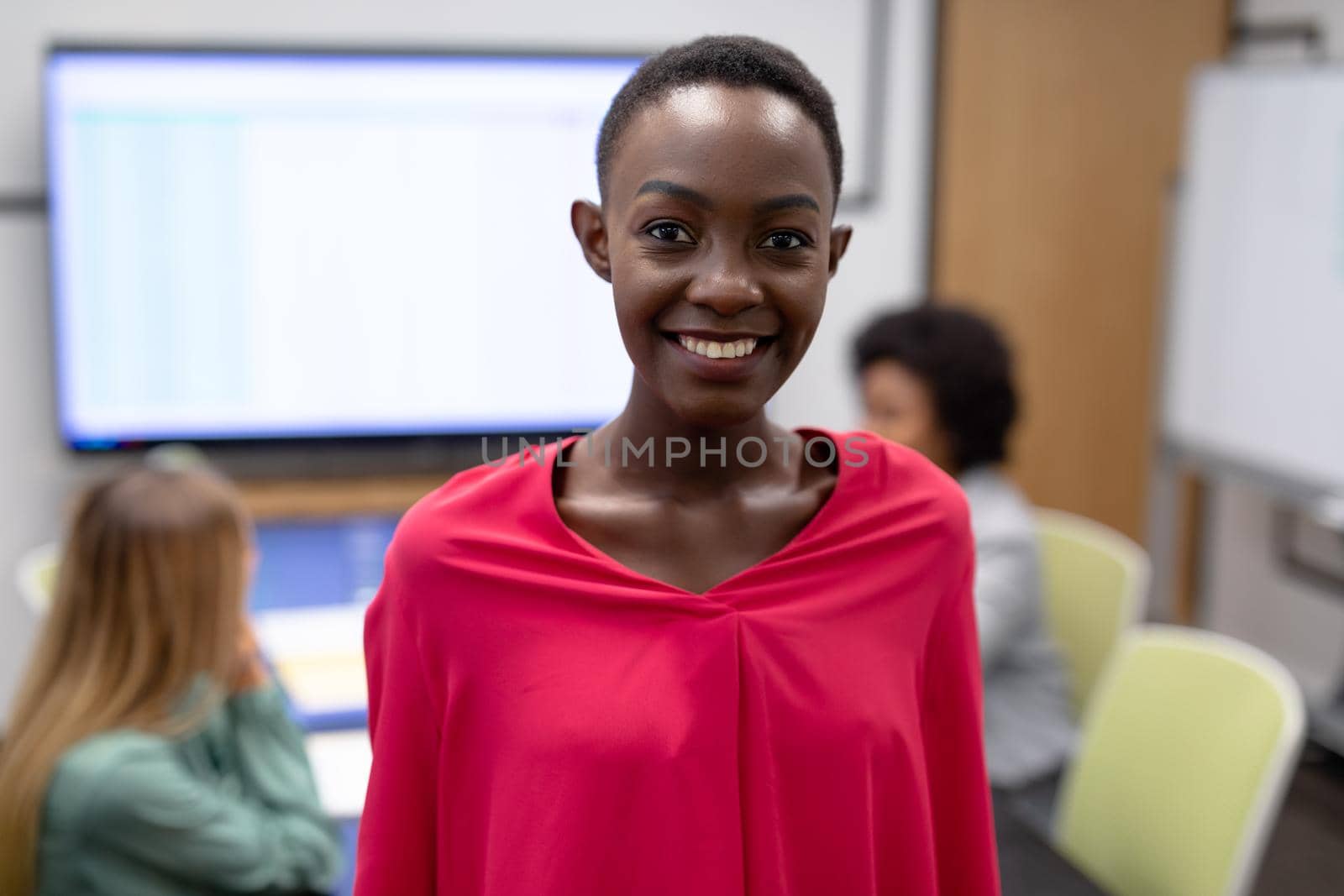 Portrait of african american businesswoman in meeting room looking to camera and smiling. business person at work in modern office.