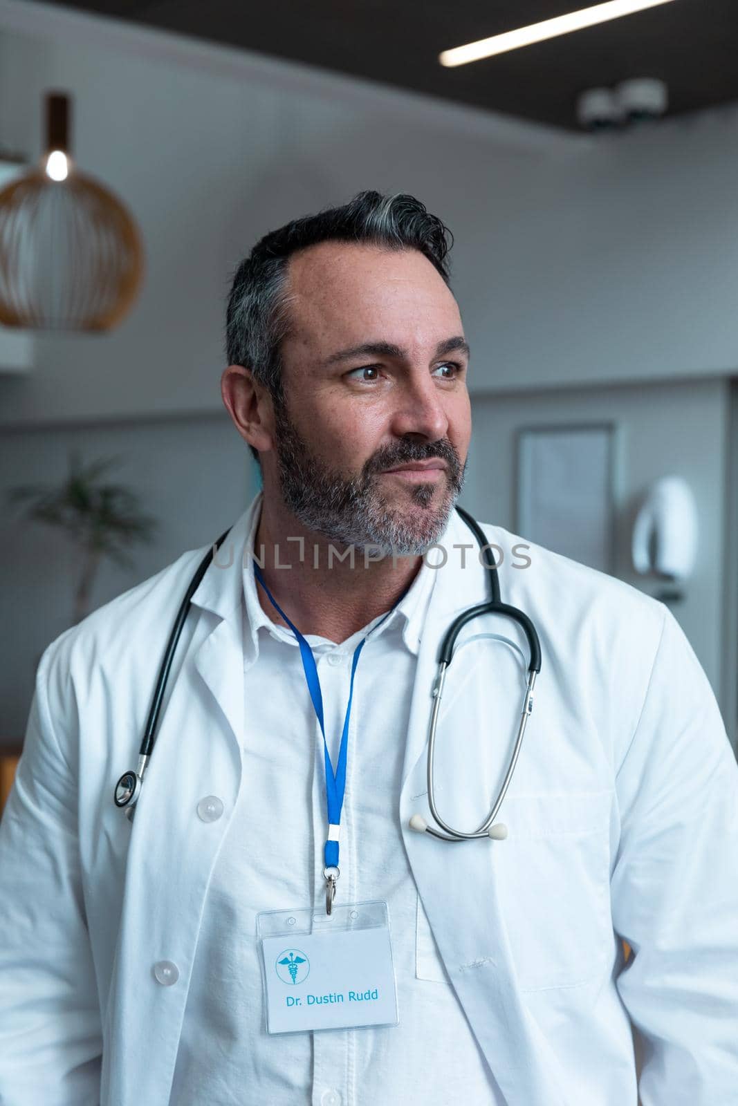 Portrait of caucasian male doctor with stethoscope wearing lab coat in hospital. medicine, health and healthcare services during covid 19 coronavirus pandemic.