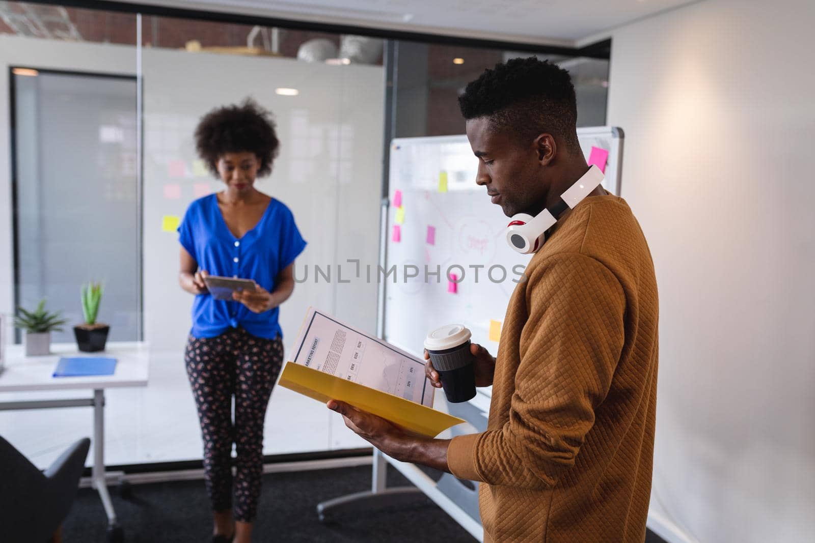 Diverse male and female colleagues standing in front of whiteboard having discussion by Wavebreakmedia