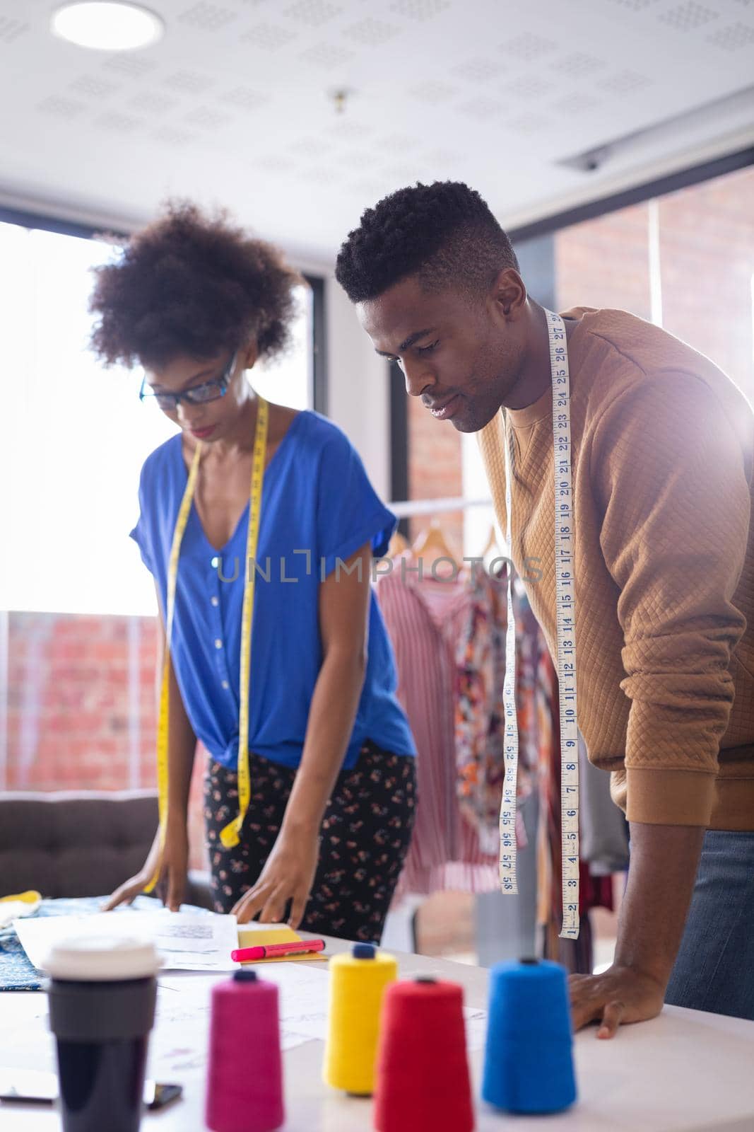 Diverse male and female fashion designers at work with tailor centimeters on necks by Wavebreakmedia